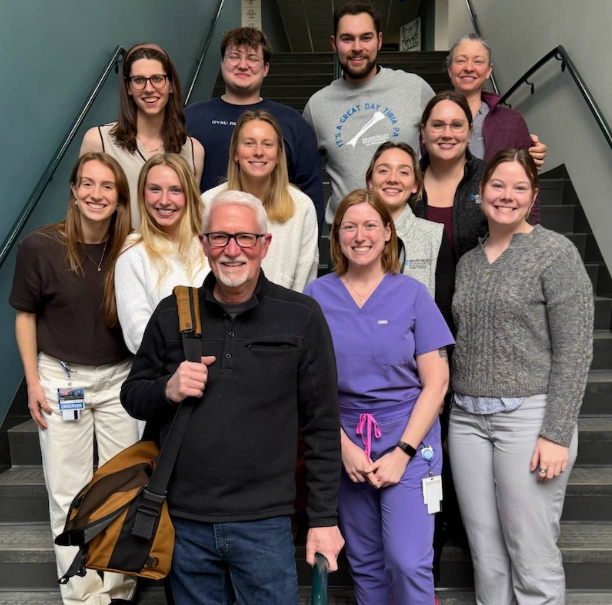 A group photo of students standing in a staircase with their instructor.